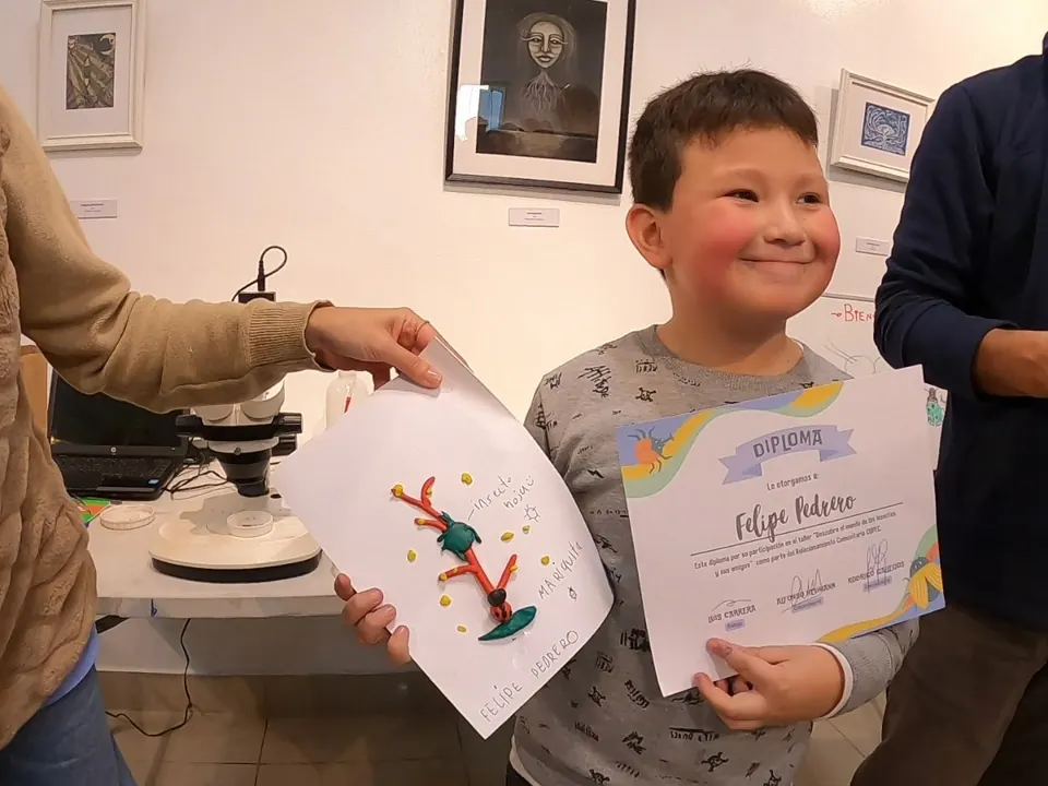 Entrega de diploma a un participante del taller sobre el mundo de los insectos