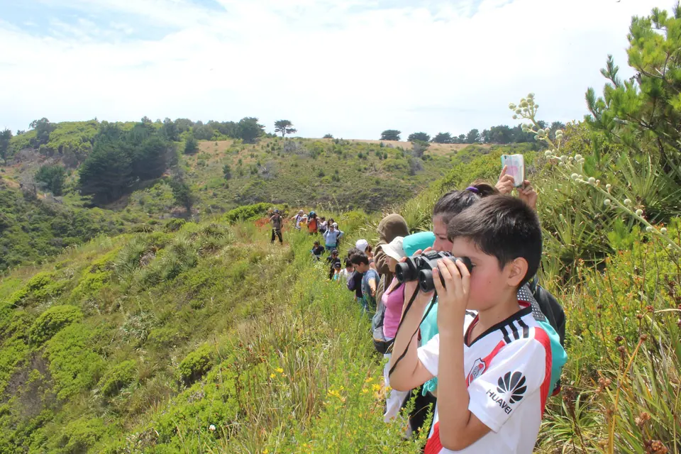 Estudiante observando aves con binoculares